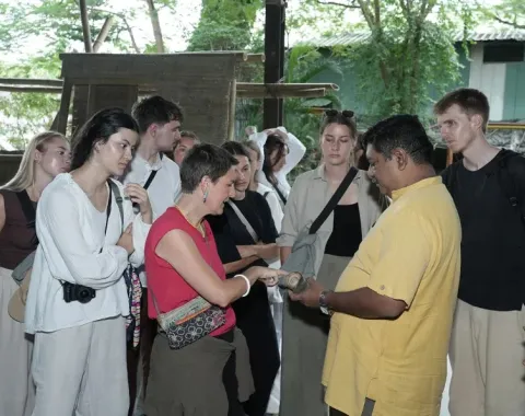 Gruppe Menschen mit einem Stück Bambus in der Hand 