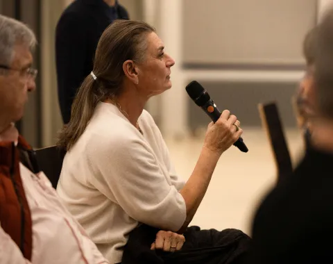 Eine Frau aus dem Publikum, die in ein Mikrofon spricht. 