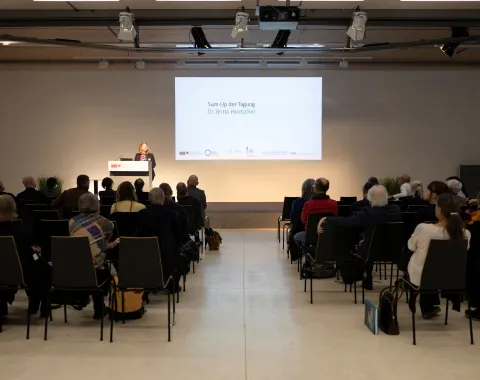 Eine vortragende Person auf einer Bühne 