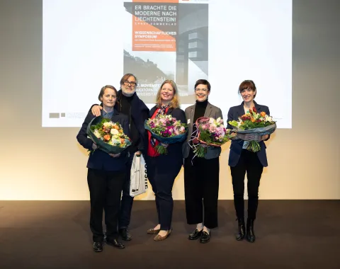 Fünf Personen auf einer Bühne mit Blumensträussen in der Hand 