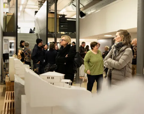 Mehrere Menschen bei der Ausstellung einer Architekturausstellung