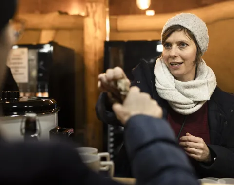 Alumni-Beauftragte schenkt warme Getränke aus