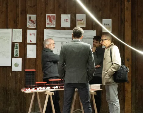 Mehrere Männer unterhalten sich in einer Ausstelllung 