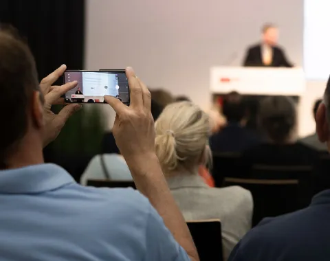 Gast fotografiert einen Vortrag beim Campus-Gespräch der Universität Liechtenstein