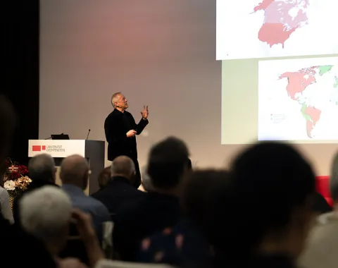 Redner präsentiert Bildinhalte vor Publikum beim Campus-Gespräch