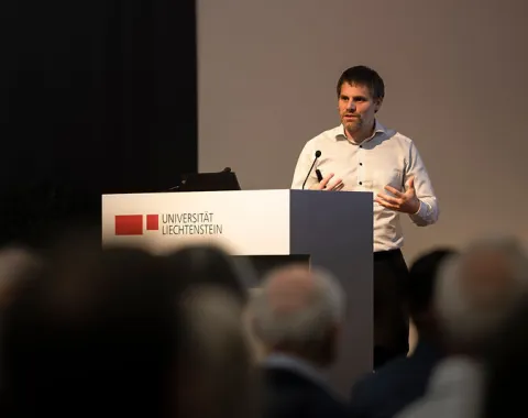 Redner spricht am Podium vor Publikum beim Campus-Gespräch