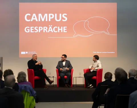 Zwei Gesprächspartner im Austausch auf der Bühne vor Publikum beim Campus-Gespräch