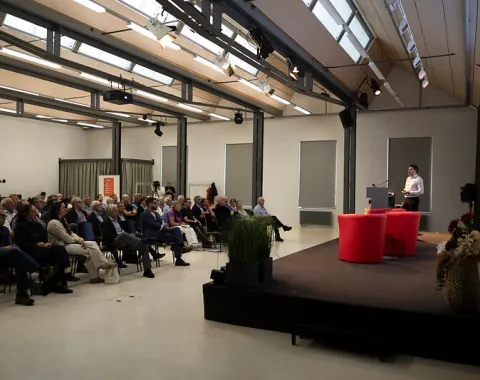 Publikum verfolgt ein Bühnengespräch mit zwei Gesprächspartnern an der Universität Liechtenstein