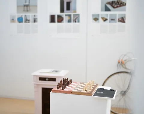 Ausstellung mit einem Schachbrett im Vordergrund
