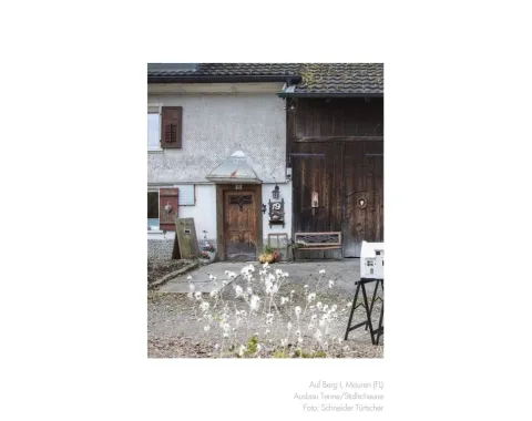 Foto eines Modells vor einem alten Bauernhaus 