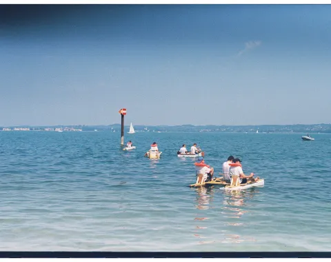 Mehrere Menschen mit selbstgebauten Booten in einem See. 