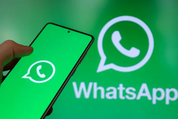 Großaufnahme eines Smartphones mit WhatsApp Logo und Hintergrundbildschirm mit WhatsApp Symbol für digitale Kommunikation