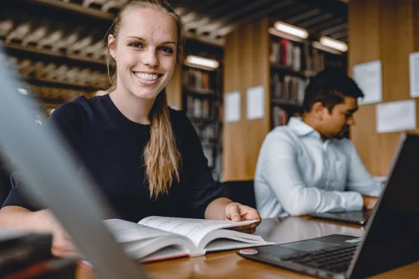 PhD Studierende der Universität Liechtenstein im Bereich Wirtschaftswissenschaften beim wissenschaftlichen Arbeiten in der Bibliothek.