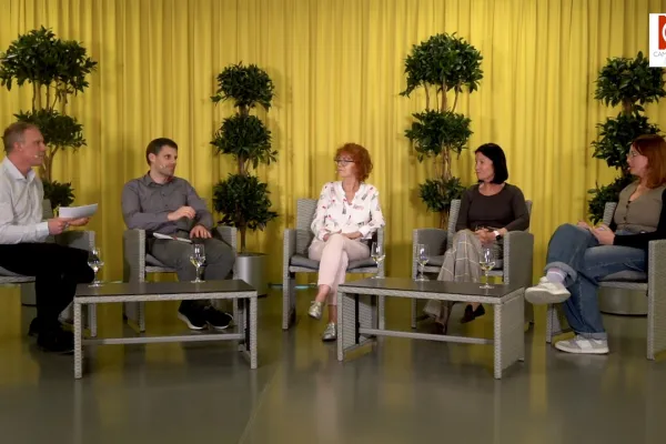 Podiumsdiskussion an der Universität Liechtenstein: Fünf Personen sitzen in einem Studio mit gelbem Vorhang und Pflanzen im Hintergrund. Sie diskutieren über Medienvielfalt und künstliche Intelligenz.