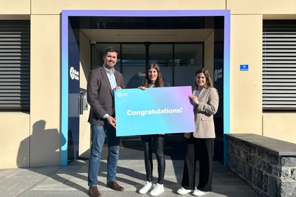 Sabrina Zimmermann, die Stipendiatin von Bank Frick, steht vor dem Gebäude der Bank Frick, bereit, am CAS Blockchain und Fintech Programm teilzunehmen.