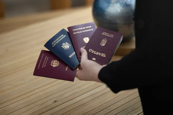 Hand hält mehrere europäische Reisepässe verschiedener Länder.