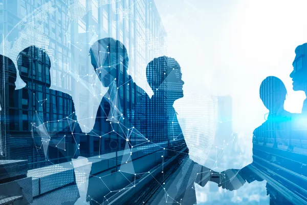 Silhouetten von Geschäftsleuten beim Handschlag mit vernetzter Weltkarte im Hintergrund.