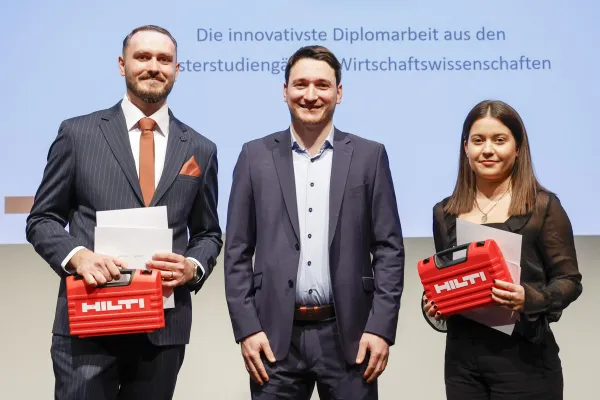 Tobias Zangerl mit Ermal Gashi und Laura Boltizar welche einen Hilti Koffer halten.
