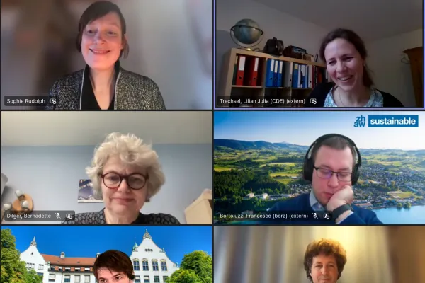 Eine Online-Podiumsdiskussion mit neun Teilnehmern in einem Videokonferenz-Layout. Die Teilnehmer sind in individuellen Kacheln zu sehen, einige mit virtuellen Hintergründen. Alle wirken konzentriert und engagiert.