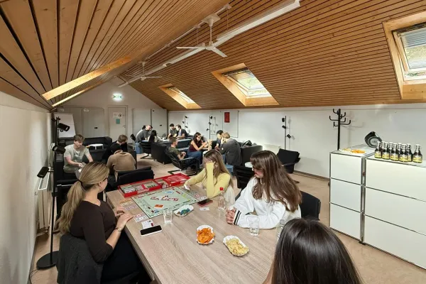 Mehrere Studierende sitzen in einem Raum und spielen