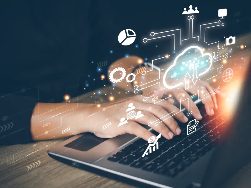 Mann arbeitet am Laptop mit eingefügten Symbolen für Cloud Computing